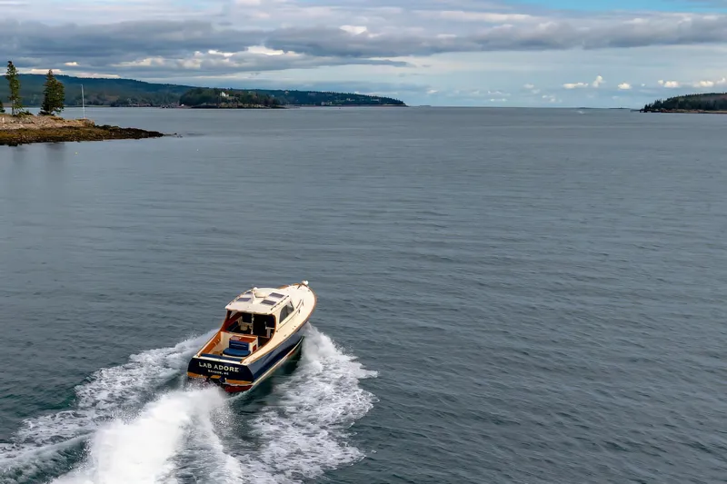 Lab Adore Yacht Photos Pics 2003 Hinckley Picnic Boat EP cruising on a scenic coastal waterway.