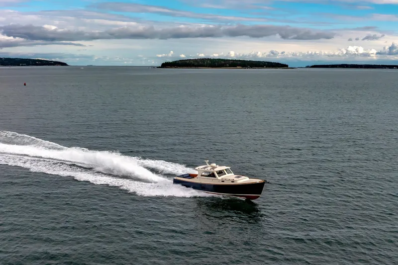 Lab Adore Yacht Photos Pics 2003 Hinckley Picnic Boat EP cruising on open water under a cloudy sky.