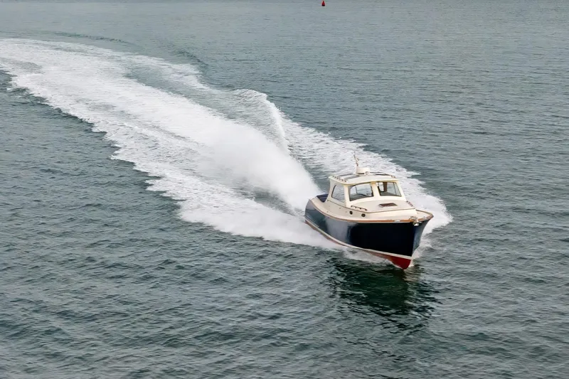 Lab Adore Yacht Photos Pics 2003 Hinckley Picnic Boat EP cruising on open water, leaving a wake.