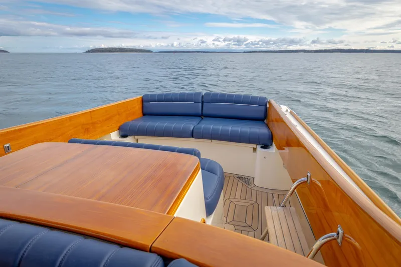 Lab Adore Yacht Photos Pics 2003 Hinckley Picnic Boat EP with blue seating and wooden deck on open water.