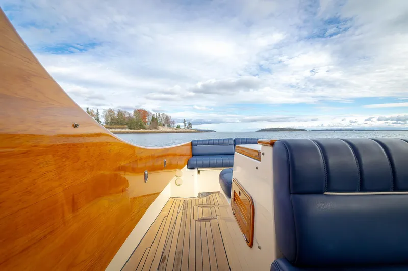 Lab Adore Yacht Photos Pics 2003 Hinckley Picnic Boat EP interior with blue seating and wooden accents on open water.