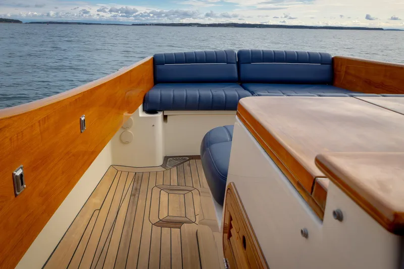 Lab Adore Yacht Photos Pics 2003 Hinckley Picnic Boat EP with wooden deck and blue seating on open water.