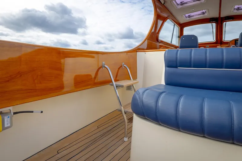 Lab Adore Yacht Photos Pics Interior of 2003 Hinckley Picnic Boat EP with blue seating and wooden accents.