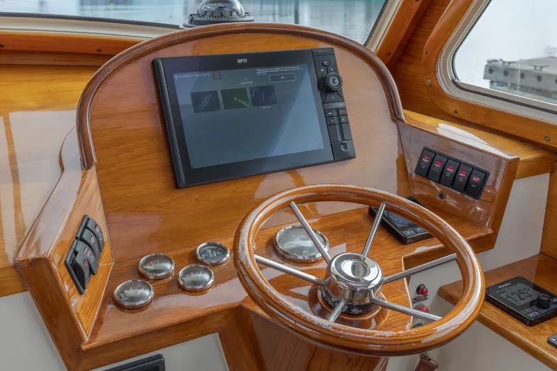 Lab Adore Yacht Photos Pics 2003 Hinckley Picnic Boat EP helm with wooden dashboard and modern navigation equipment.