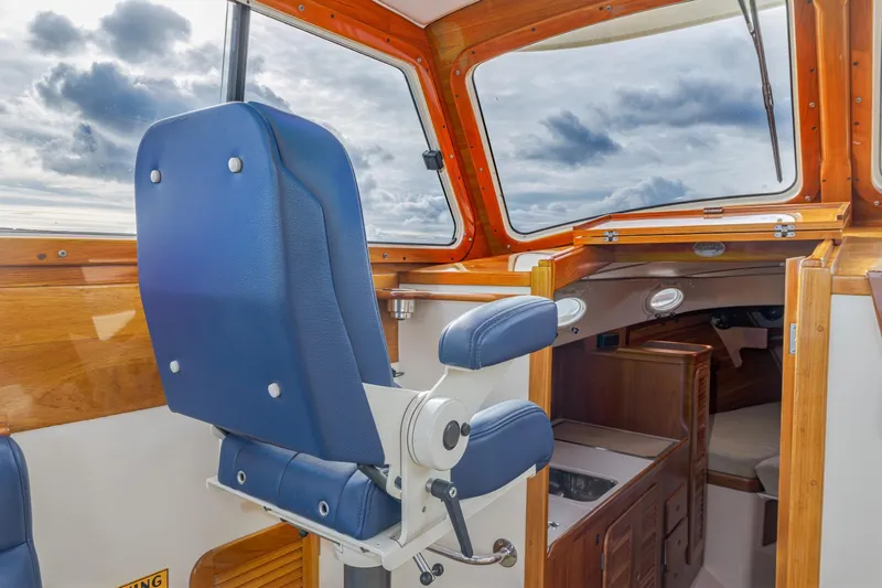 Lab Adore Yacht Photos Pics 2003 Hinckley Picnic Boat EP interior with blue captain's chair and wooden cabin details.