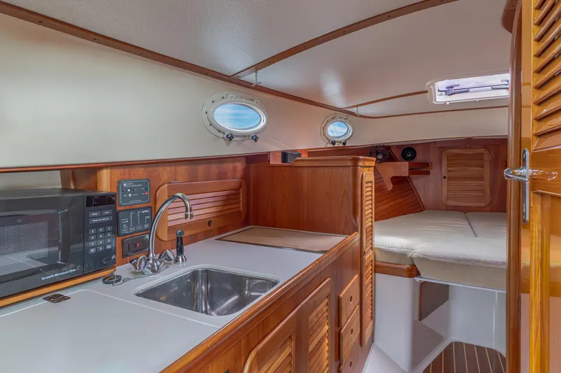 Lab Adore Yacht Photos Pics 2003 Hinckley Picnic Boat EP interior with kitchenette, sink, and cozy sleeping area.