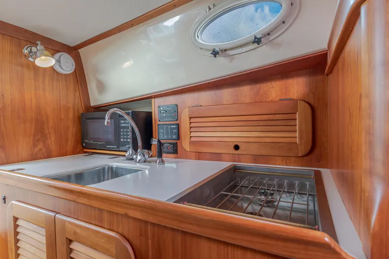 Lab Adore Yacht Photos Pics 2003 Hinckley Picnic Boat EP interior kitchen with sink, stove, and microwave.