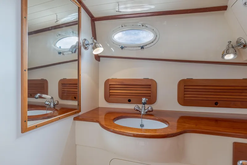 Lab Adore Yacht Photos Pics 2003 Hinckley Picnic Boat EP bathroom with wooden accents and oval porthole window.