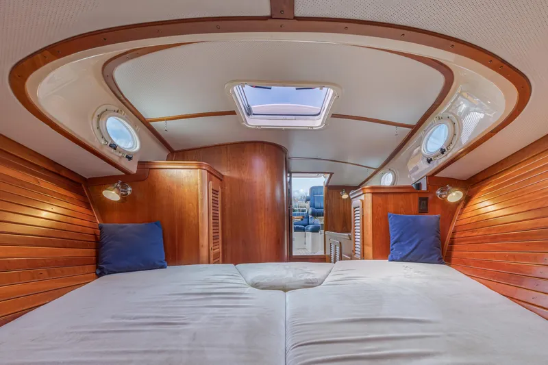 Lab Adore Yacht Photos Pics Interior of 2003 Hinckley Picnic Boat EP with wooden paneling and cozy bedding.