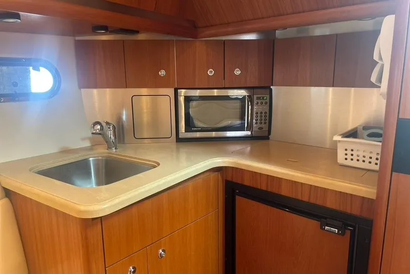  Yacht Photos Pics 2005 Tiara Yachts 3600 Sovran kitchen with sink, microwave, and wooden cabinetry.