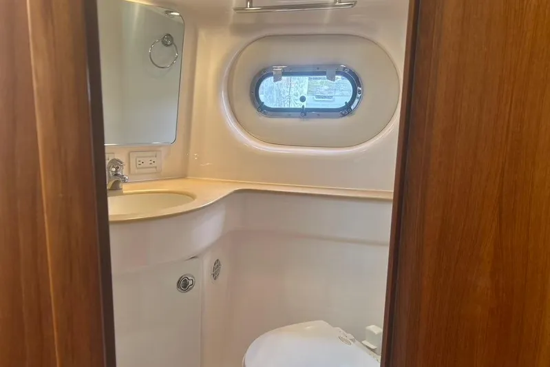  Yacht Photos Pics 2005 Tiara Yachts 3600 Sovran bathroom with sink, mirror, and porthole window.