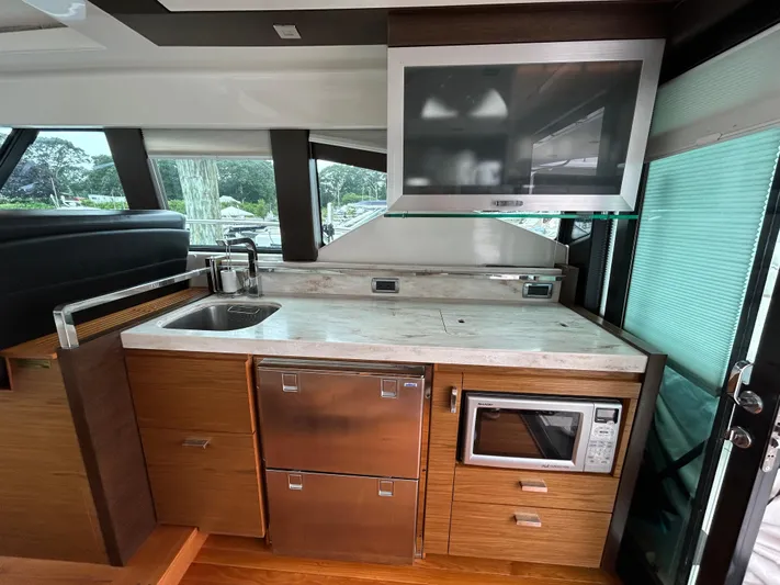  Yacht Photos Pics 2015 Tiara Yachts C44 Coupe interior kitchen with sink, microwave, and TV.
