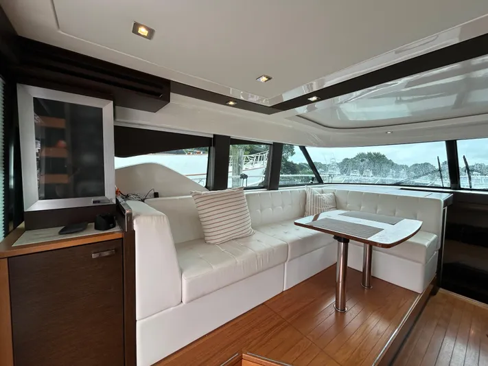  Yacht Photos Pics Luxurious interior of 2015 Tiara Yachts C44 Coupe with white seating and wooden accents.