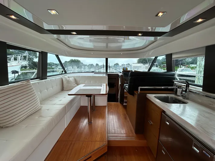  Yacht Photos Pics Luxurious interior of 2015 Tiara Yachts C44 Coupe with seating and kitchenette.
