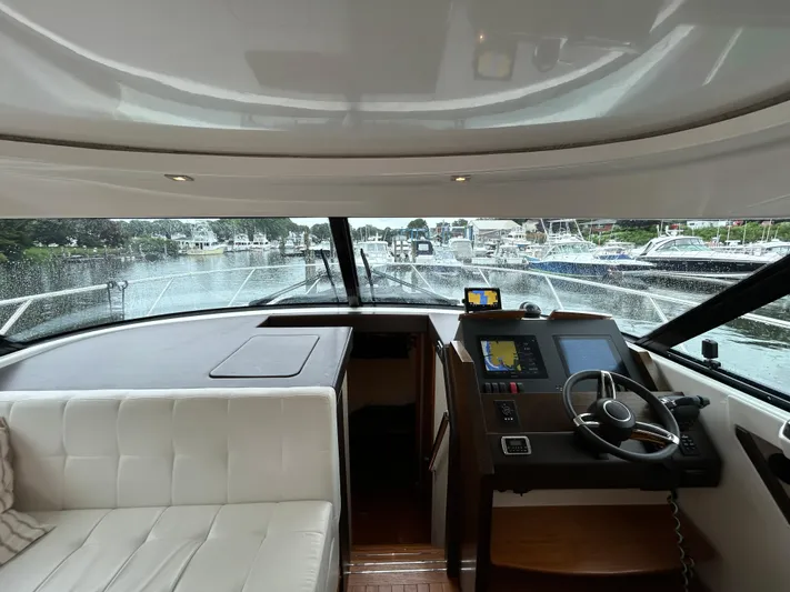  Yacht Photos Pics Interior view of 2015 Tiara Yachts C44 Coupe, featuring helm and seating area.