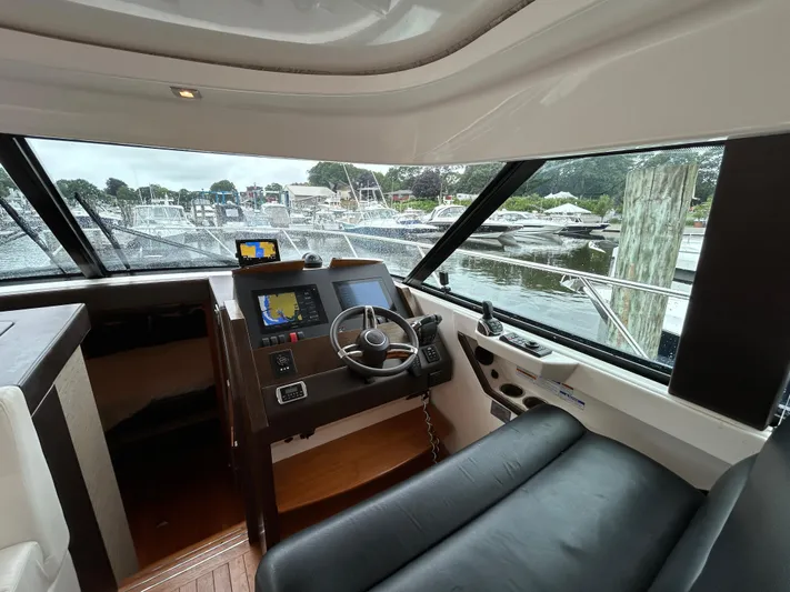  Yacht Photos Pics Interior view of 2015 Tiara Yachts C44 Coupe helm with marina in background.