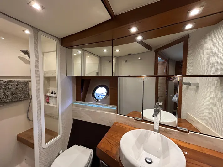  Yacht Photos Pics Luxurious bathroom interior of 2015 Tiara Yachts C44 Coupe with modern fixtures and porthole window.