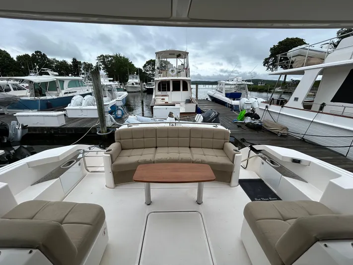  Yacht Photos Pics 2015 Tiara Yachts C44 Coupe interior with beige seating and wooden table at marina.