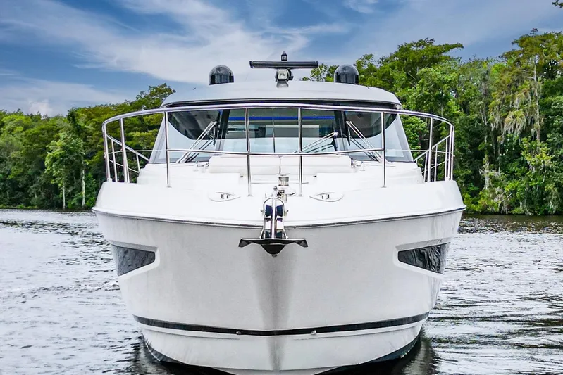 Frivolous Yacht Photos Pics 2021 Riviera 5400 Sport Yacht Platinum Edition on a serene waterway.
