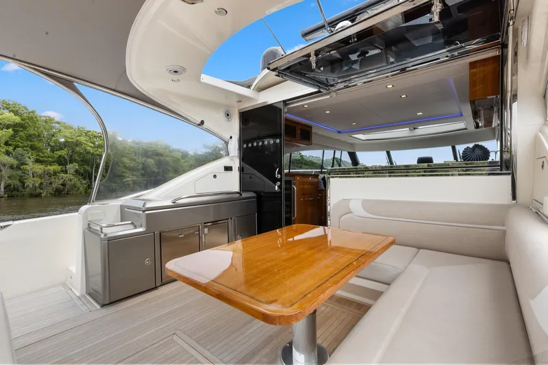 Frivolous Yacht Photos Pics Luxurious interior of 2021 Riviera 5400 Sport Yacht Platinum Edition with elegant seating and dining area.