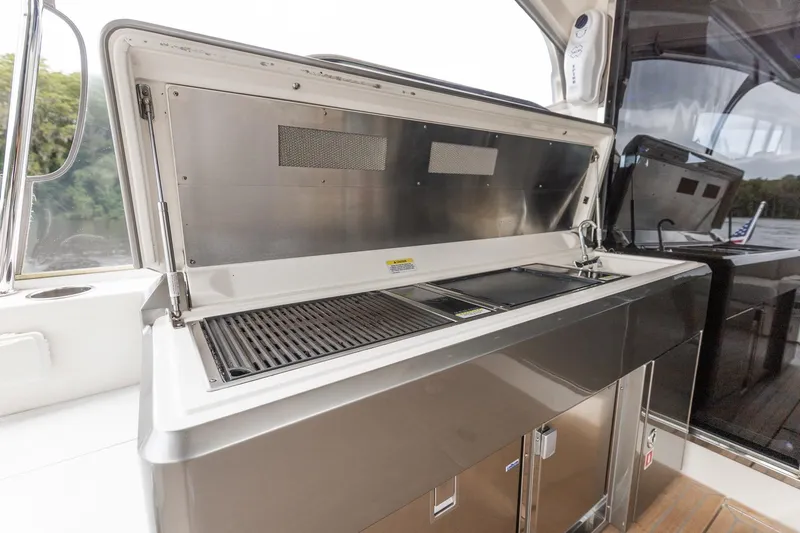 Frivolous Yacht Photos Pics Outdoor kitchen on 2021 Riviera 5400 Sport Yacht Platinum Edition, featuring grill and sink.