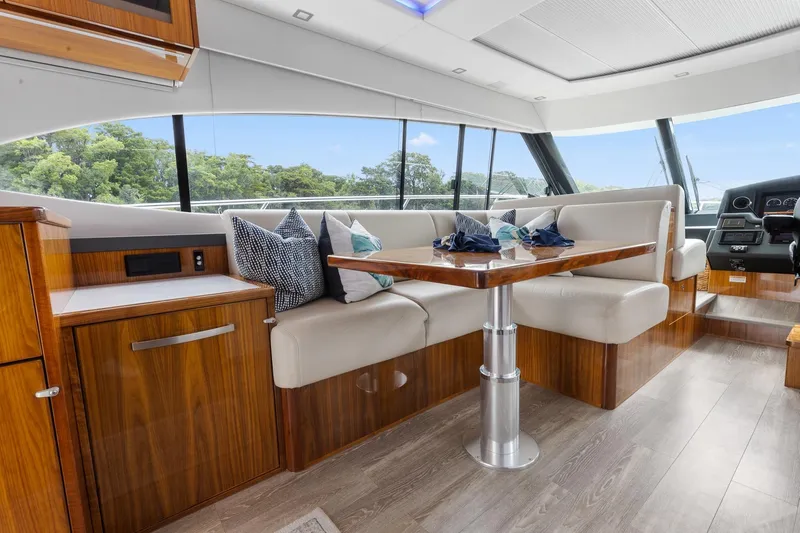 Frivolous Yacht Photos Pics Luxurious interior of 2021 Riviera 5400 Sport Yacht Platinum Edition with elegant seating and table.