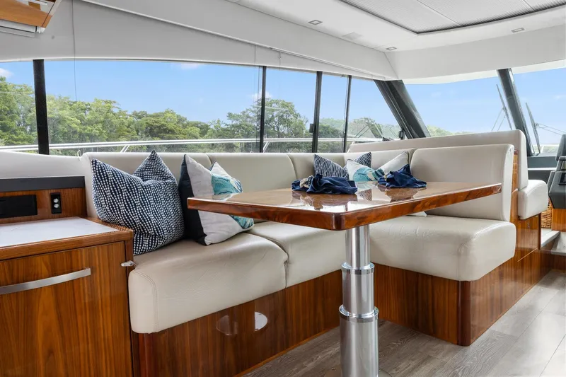 Frivolous Yacht Photos Pics Luxurious interior of 2021 Riviera 5400 Sport Yacht Platinum Edition with elegant seating and table.