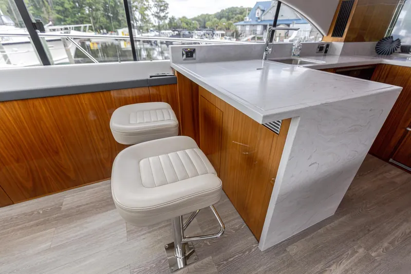 Frivolous Yacht Photos Pics Interior of 2021 Riviera 5400 Sport Yacht with modern bar stools and sleek countertop.