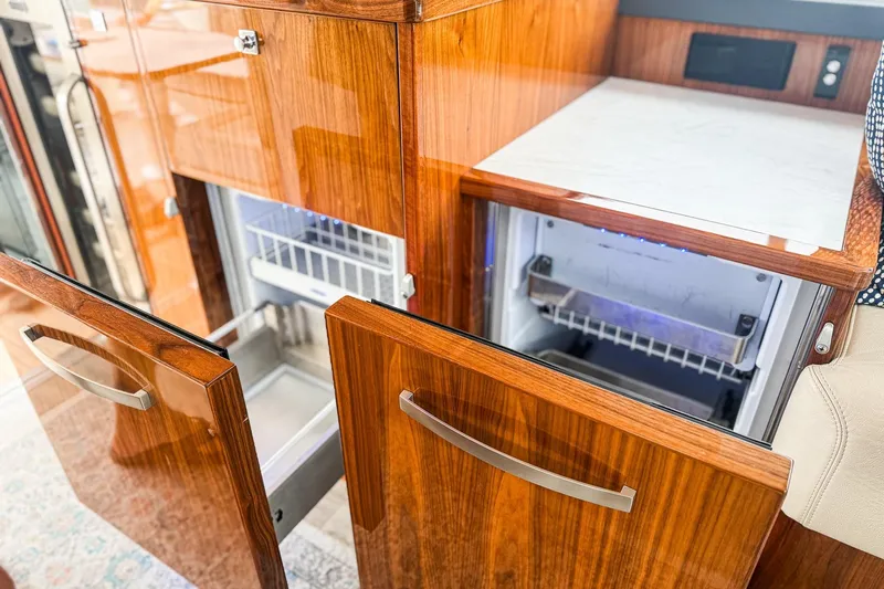 Frivolous Yacht Photos Pics Luxurious wooden cabinetry and open fridge in 2021 Riviera 5400 Sport Yacht Platinum Edition.
