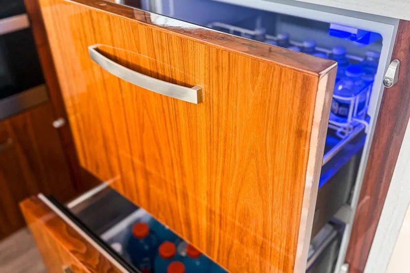 Frivolous Yacht Photos Pics Luxury yacht interior with open wooden drawer fridge, showcasing beverages. Riviera 5400 Sport Yacht 2021.