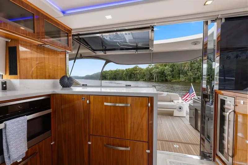Frivolous Yacht Photos Pics Luxurious interior of 2021 Riviera 5400 Sport Yacht Platinum Edition with scenic river view.