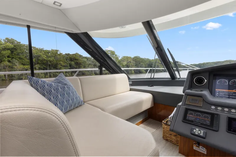 Frivolous Yacht Photos Pics Interior of 2021 Riviera 5400 Sport Yacht Platinum Edition with plush seating and modern dashboard.