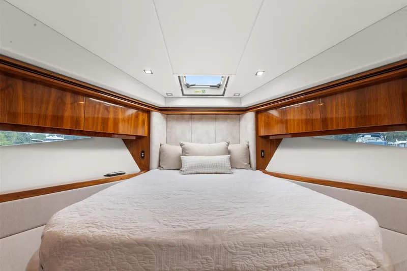 Frivolous Yacht Photos Pics Luxurious bedroom interior of 2021 Riviera 5400 Sport Yacht Platinum Edition with elegant wood finishes.