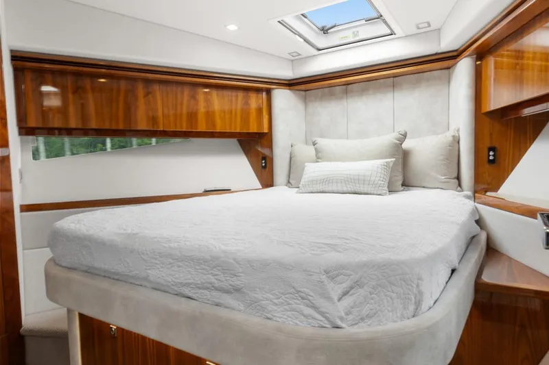 Frivolous Yacht Photos Pics Luxurious bedroom interior of 2021 Riviera 5400 Sport Yacht Platinum Edition with elegant wood finishes.