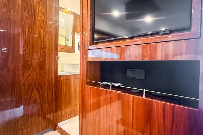 Frivolous Yacht Photos Pics Luxurious interior of 2021 Riviera 5400 Sport Yacht with wood paneling and TV.