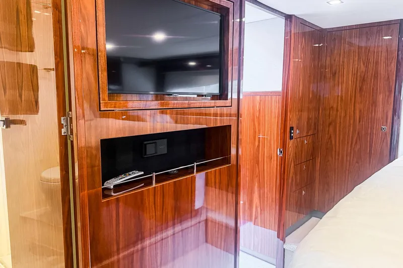 Frivolous Yacht Photos Pics Luxurious interior of 2021 Riviera 5400 Sport Yacht Platinum Edition with wood paneling and TV.