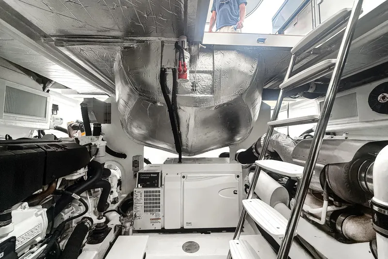 Frivolous Yacht Photos Pics Engine room of 2021 Riviera 5400 Sport Yacht Platinum Edition with visible machinery and ladder.