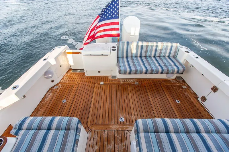 Cavu 4 Yacht Photos Pics Hinckley Sport Boat 40 X 2022 with striped seating and American flag on teak deck.