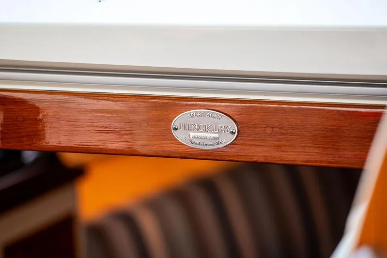 Cavu 4 Yacht Photos Pics 2022 Hinckley Sport Boat 40 X nameplate on polished wood surface.