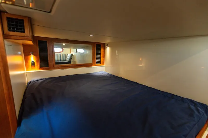 Cavu 4 Yacht Photos Pics 2022 Hinckley Sport Boat 40 X cabin interior with cozy bed and wooden accents.