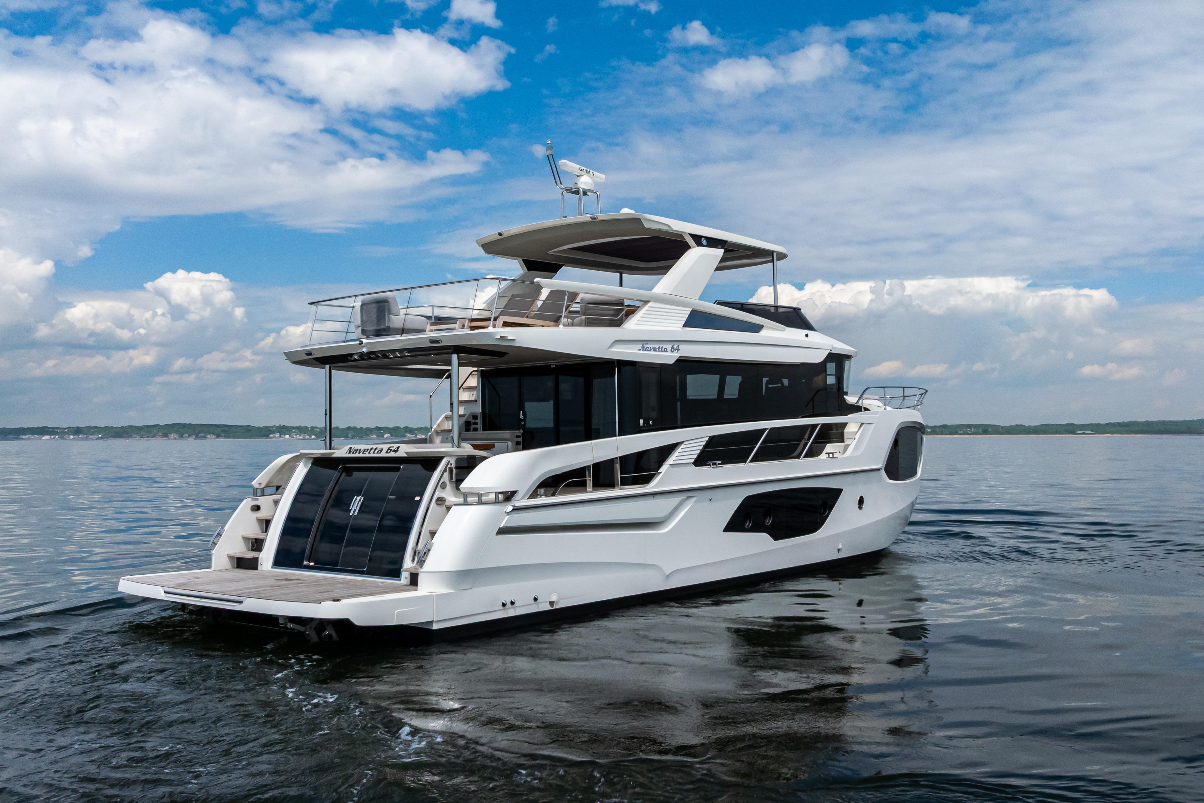 2025 Absolute Navetta 64 yacht cruising on calm waters under a blue sky.