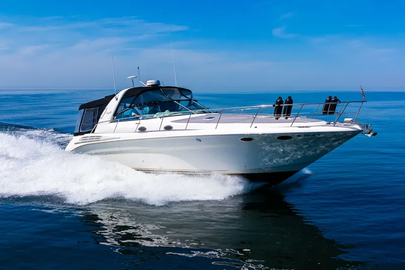  Yacht Photos Pics 1997 Sea Ray 400 Sundancer cruising on open water under a clear blue sky.