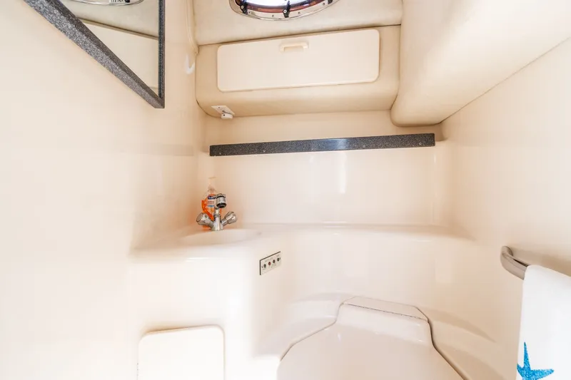  Yacht Photos Pics 1997 Sea Ray 400 Sundancer bathroom with sink, mirror, and storage cabinet.