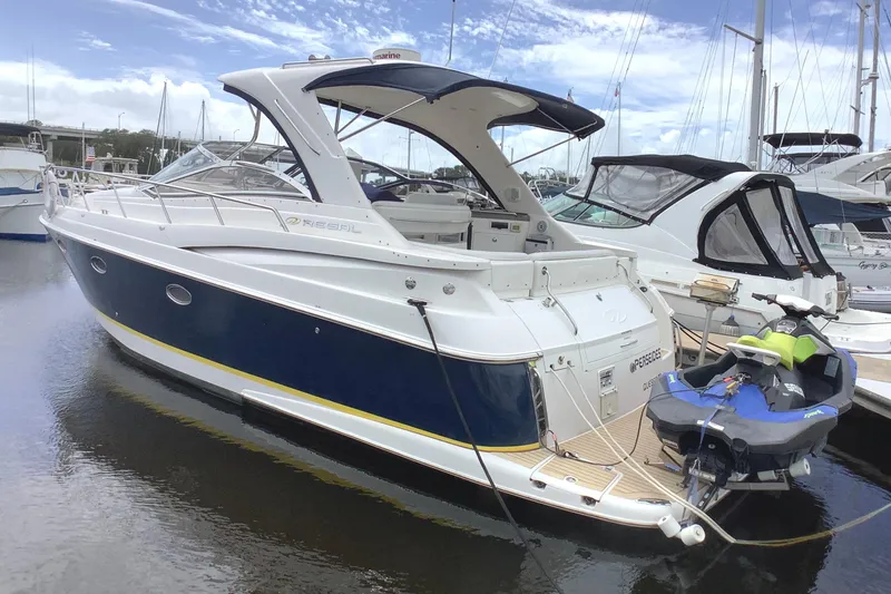 Perseides Yacht Photos Pics 2005 Regal Commodore 3860 yacht docked with jet ski, under blue sky.