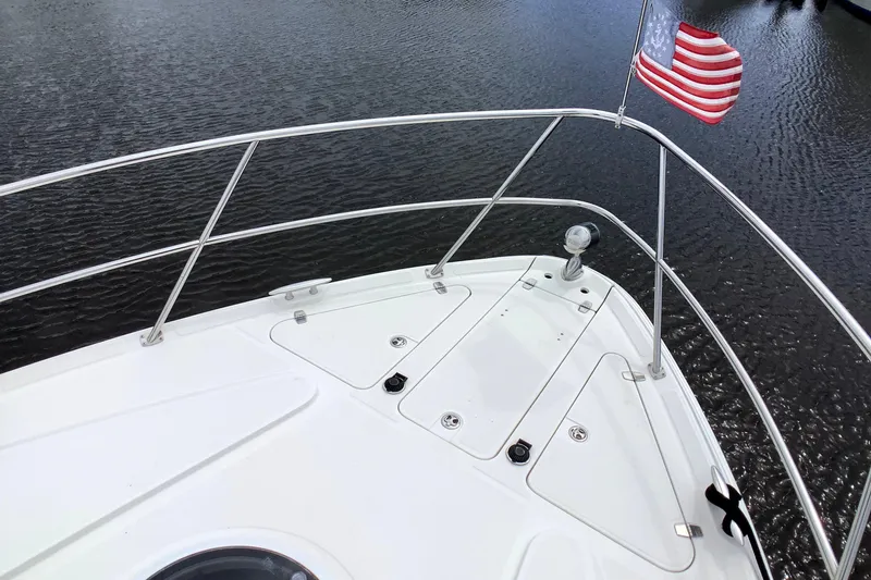 Perseides Yacht Photos Pics Bow of 2005 Regal Commodore 3860 yacht with American flag, on calm water.