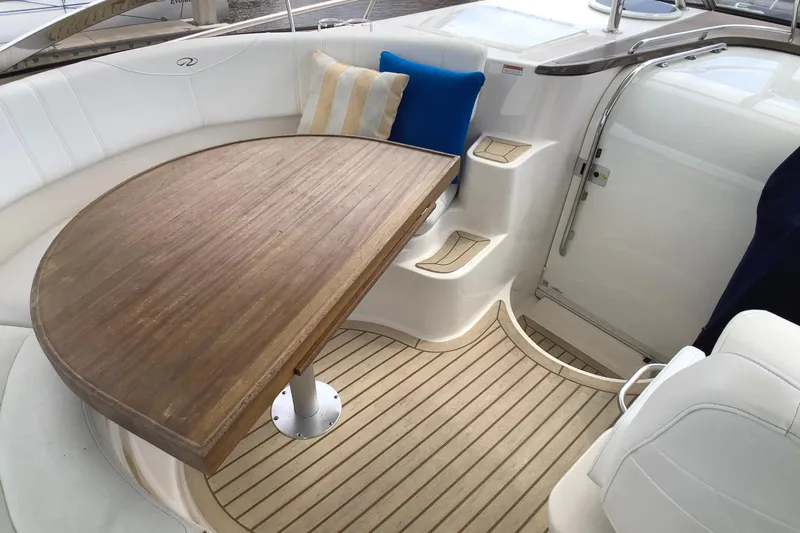 Perseides Yacht Photos Pics 2005 Regal Commodore 3860 yacht interior with wooden table and cushioned seating.