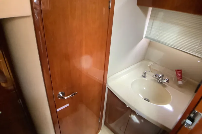 Perseides Yacht Photos Pics 2005 Regal Commodore 3860 yacht bathroom with wooden door and sink area.