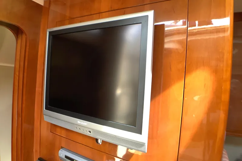 Perseides Yacht Photos Pics Flat-screen TV mounted on wood panel inside 2005 Regal Commodore 3860 yacht.