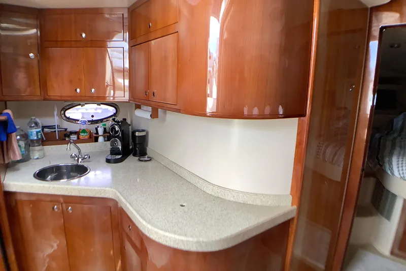 Perseides Yacht Photos Pics 2005 Regal Commodore 3860 yacht interior with wooden cabinets and compact kitchen area.