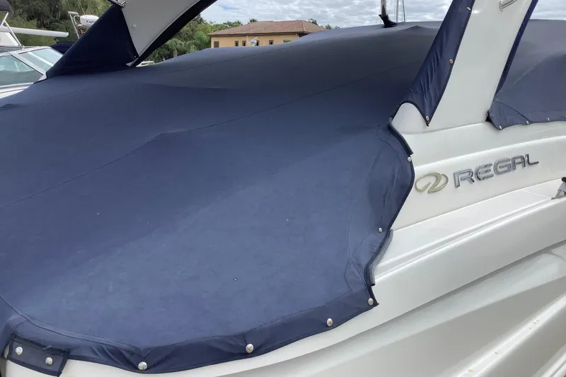 Perseides Yacht Photos Pics 2005 Regal Commodore 3860 boat with blue cover, docked outdoors.